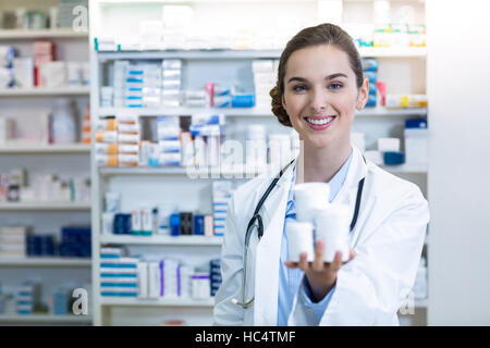 Lächelnd zeigt Medikamentenbehälter in Apotheke Apotheker Stockfoto