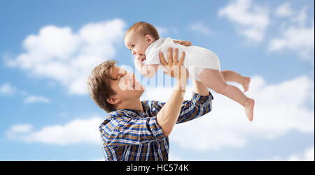 glückliche junge Vater über blauen Himmel mit Baby spielen Stockfoto