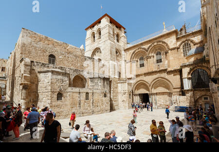 JERUSALEM, ISRAEL - 6. April 2016: Touristen und Pigrims gehen und sitzen auf einem Platz am Eingang der Kirche des Heiligen Grabes in Jerusalem auf Stockfoto