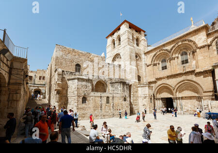 JERUSALEM, ISRAEL - 6. April 2016: Touristen und Pigrims gehen und sitzen auf einem Platz am Eingang der Kirche des Heiligen Grabes in Jerusalem auf Stockfoto