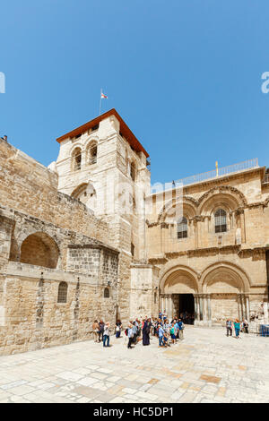 JERUSALEM, ISRAEL - 6. April 2016: Touristen und Pigrims gehen und sitzen auf einem Platz am Eingang der Kirche des Heiligen Grabes in Jerusalem auf Stockfoto