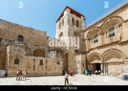 JERUSALEM, ISRAEL - 6. April 2016: Touristen und Pigrims gehen und sitzen auf einem Platz am Eingang der Kirche des Heiligen Grabes in Jerusalem auf Stockfoto