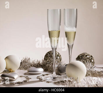 Sekt Brille mit silbernen Ornamenten und Weihnachtskugeln Stockfoto