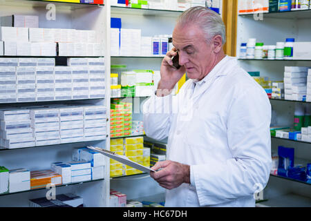 Telefonieren mit Handy während der Überprüfung Arzneimittel Apotheker Stockfoto