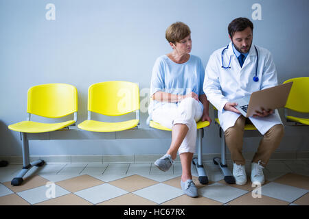 Arzt und Patient diskutieren über laptop Stockfoto