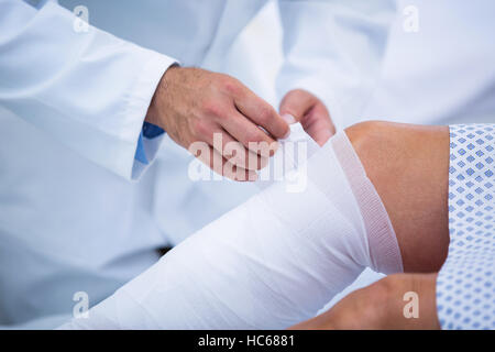 Arzt Bandagierung Bein des Patienten Stockfoto