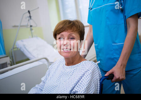 Krankenschwester Drücken deaktiviert Patienten auf einen Rollstuhl Stockfoto