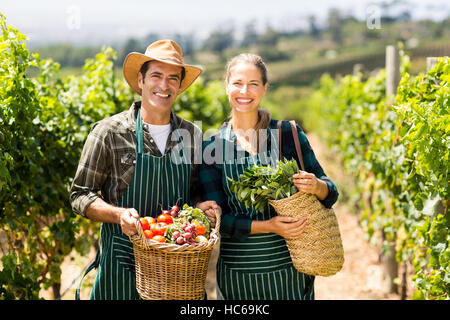 Porträt von happy Farmer paar halten Körbe mit Gemüse Stockfoto