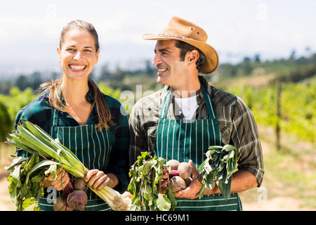 Glücklich Landwirt paar Blattgemüse halten Stockfoto
