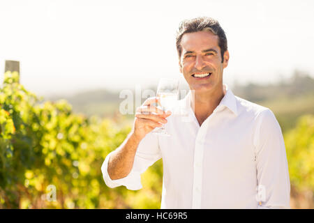 Porträt von lächelnden männlichen Winzer mit einem Glas Wein Stockfoto