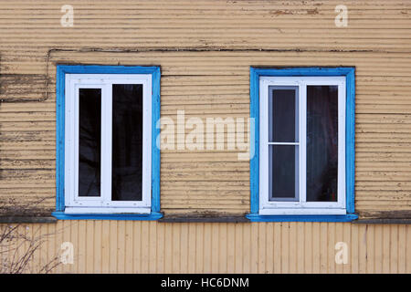 Zwei Fenster im blau eingerahmt in einem Holzhaus lackiert Beige Farbe Stockfoto