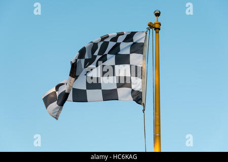 Karierte Flagge weht im Wind auf eine Fahnenstange Stockfoto