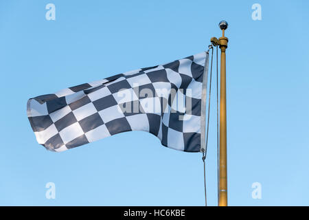 Karierte Flagge weht im Wind auf eine Fahnenstange Stockfoto