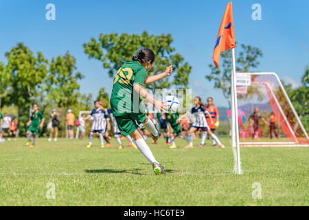 Eine Mädchen sind ein Eckball treten, an einer Ecke des Fußballfeldes. Stockfoto