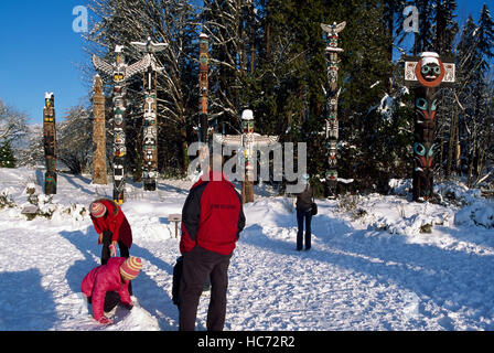 Stanley Park Totempfähle am Brockton Point, Vancouver, BC, Britisch-Kolumbien, Kanada - Touristen, die im Winter Stockfoto