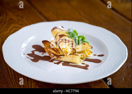 Süße Crepes mit heißer Schokolade schön Docorated für Kinder-Menü Stockfoto