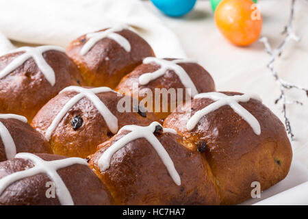 Hausgemachte Hot Cross Buns am Ostertisch Stockfoto