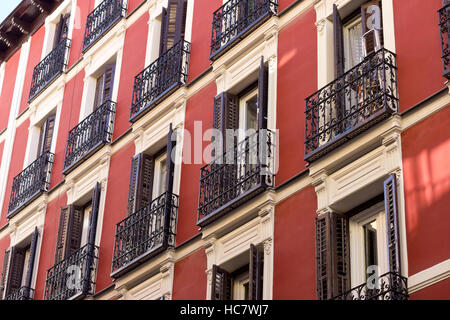 Geöffnete Fenster rote Fassade (Madrid, Spanien). Stockfoto