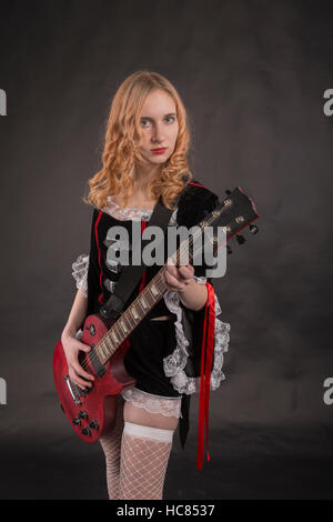 Weibliche Gitarre spielen. Shooting im Studio. Stockfoto