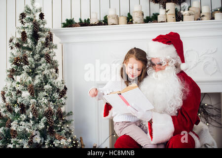 Santa Claus und Kind zu Hause. Weihnachts-Geschenk. Familienurlaub-Konzept Stockfoto