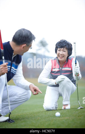 Smiling.Senior paar Golfer sitzen Angesicht zu Angesicht Stockfoto