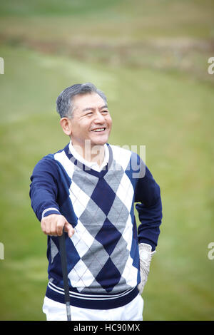 Lächelnde männlichen Golfer posiert in Feld Stockfoto