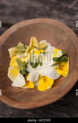 Essbare Blumen in einer Holzschale / Stiefmütterchen Stockfoto