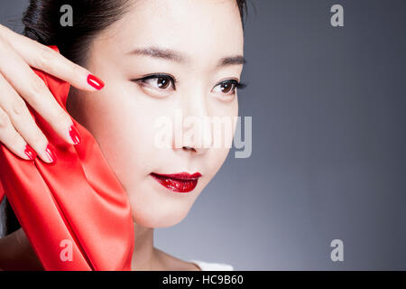 Porträt der jungen Koreanerin mit roten Lippen und roten Nägeln Stockfoto