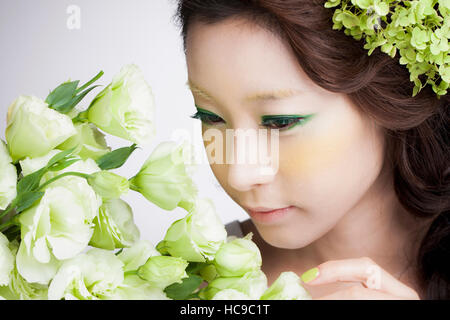 Porträt der jungen Koreanerin Blumen riechen Stockfoto