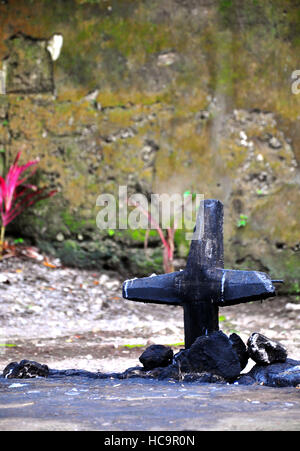 A Kreuz verbrannt ist links von einem Einheimischen auf den alten Guiob Kirche Ruinen zerstört durch Vulkanausbruch auf Camiguin Island. Stockfoto