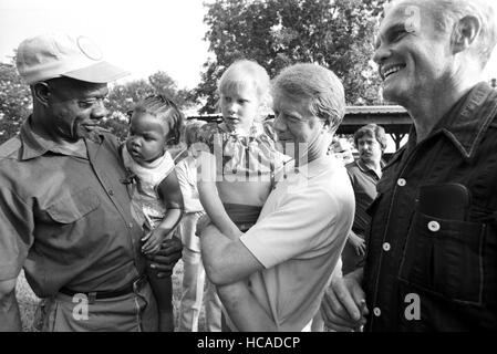 Astronaut und US-Senator aus Ohio, John Glenn ist für US-Vizepräsident 1976 Interview mit Jimmy Carter in Ebenen, GA. Hier treffen sich Carter, seine Tochter Amy und Glenn Carters Farmpächter Leonard Wright mit seinem Kleinkind Tochter auf die Familie Ackerland außerhalb Plains, GA. Stockfoto