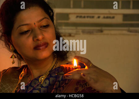 Junge indische Frau mit kleinen irdenen Diya oder Lampe während Diwali Festival, Pune, Maharashtra, Indien Stockfoto