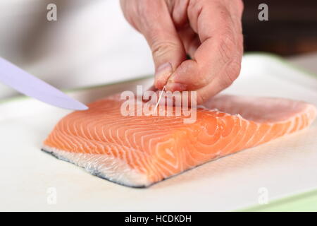 Lachsfilet entfernen Knochen. Lachs in Blätterteig-Serie zu machen. Stockfoto