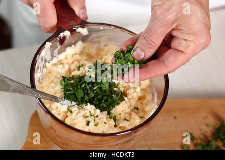 Gehackte Petersilie in Schüssel mit Füllung. Lachs in Blätterteig-Serie zu machen. Stockfoto