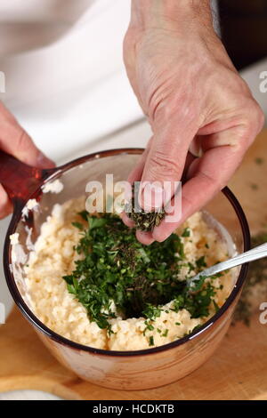 Estragon in Schüssel mit Füllung hinzufügen. Lachs in Blätterteig-Serie zu machen. Stockfoto