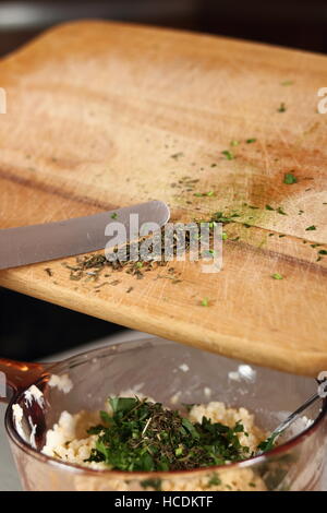 Estragon in Schüssel mit Füllung hinzufügen. Lachs in Blätterteig-Serie zu machen. Stockfoto