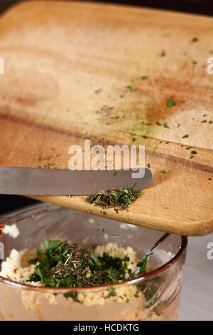 Estragon in Schüssel mit Füllung hinzufügen. Lachs in Blätterteig-Serie zu machen. Stockfoto