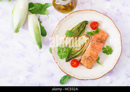 Gebackenen Lachs mit italienischen Kräutern und garniert mit Chicorée. Ansicht von oben Stockfoto