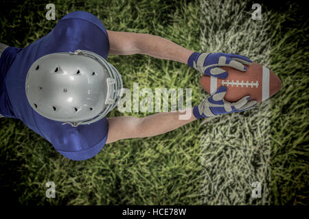 Zusammengesetztes Bild der hohen Winkel Ansicht des american Footballspieler in Richtung Ball zu erreichen Stockfoto