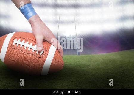 Zusammengesetztes Bild des american-Footballspieler kann den Ball 3D Stockfoto