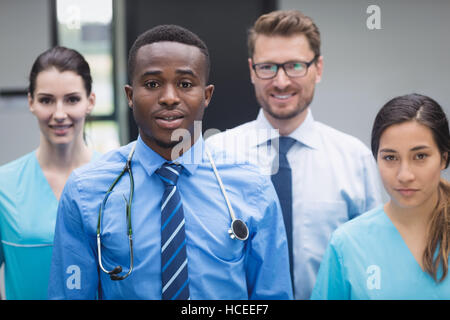 Ärzteteam stehen gemeinsam im Krankenhausflur lächelnd Stockfoto