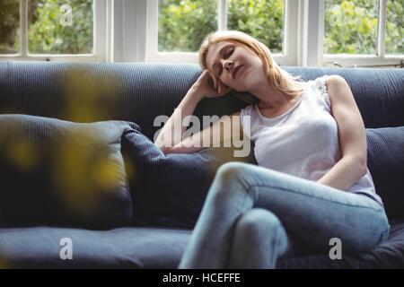 Schöne Frau am Sofa im Wohnzimmer entspannen Stockfoto