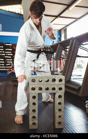 Karate Spieler brechen Betonblock Stockfoto