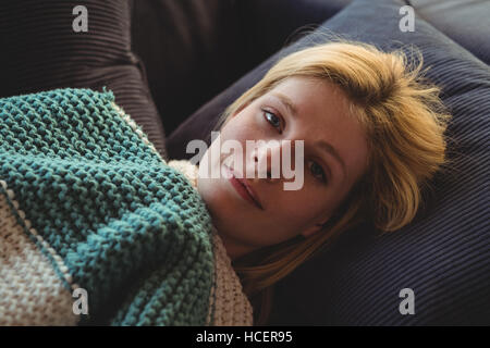 Portrait der schönen Frau liegend auf dem Sofa im Wohnzimmer Stockfoto