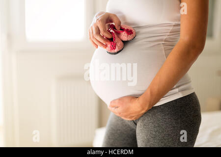 Schwangere Frau mit kleine Neugeborene Schuhe Stockfoto