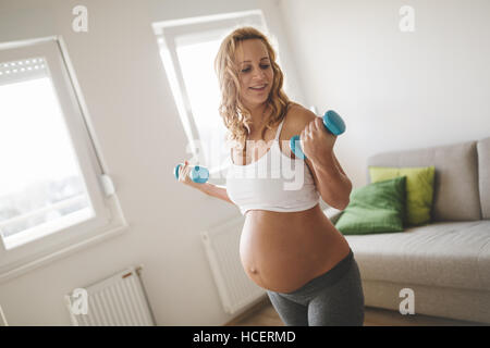 Schwangere Frau training mit Hanteln, aktiv zu bleiben Stockfoto