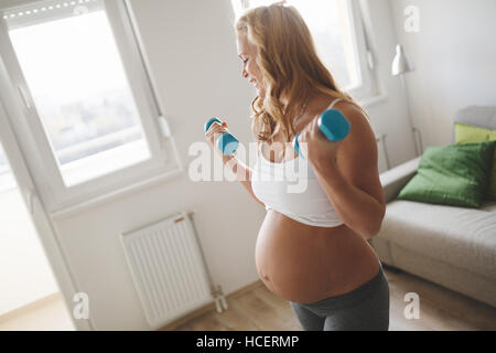 Schwangere Frau training mit Hanteln, aktiv zu bleiben Stockfoto