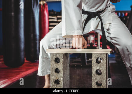 Karate Spieler brechen Holzbrett Stockfoto