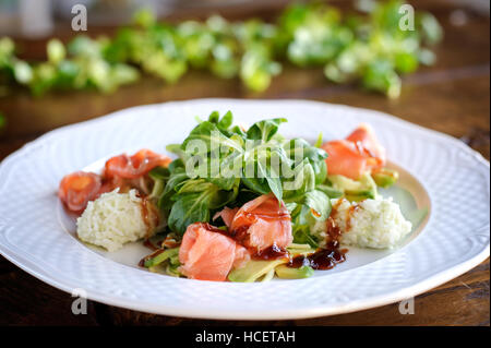 besten Restaurants Salat mit geräuchertem Lachs, Reis, Kräutern und Avocado in weißer Teller Stockfoto