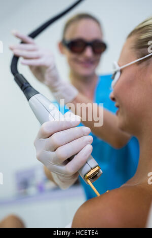 Frau, die Laser Epilation Behandlung auf die Schulter Stockfoto